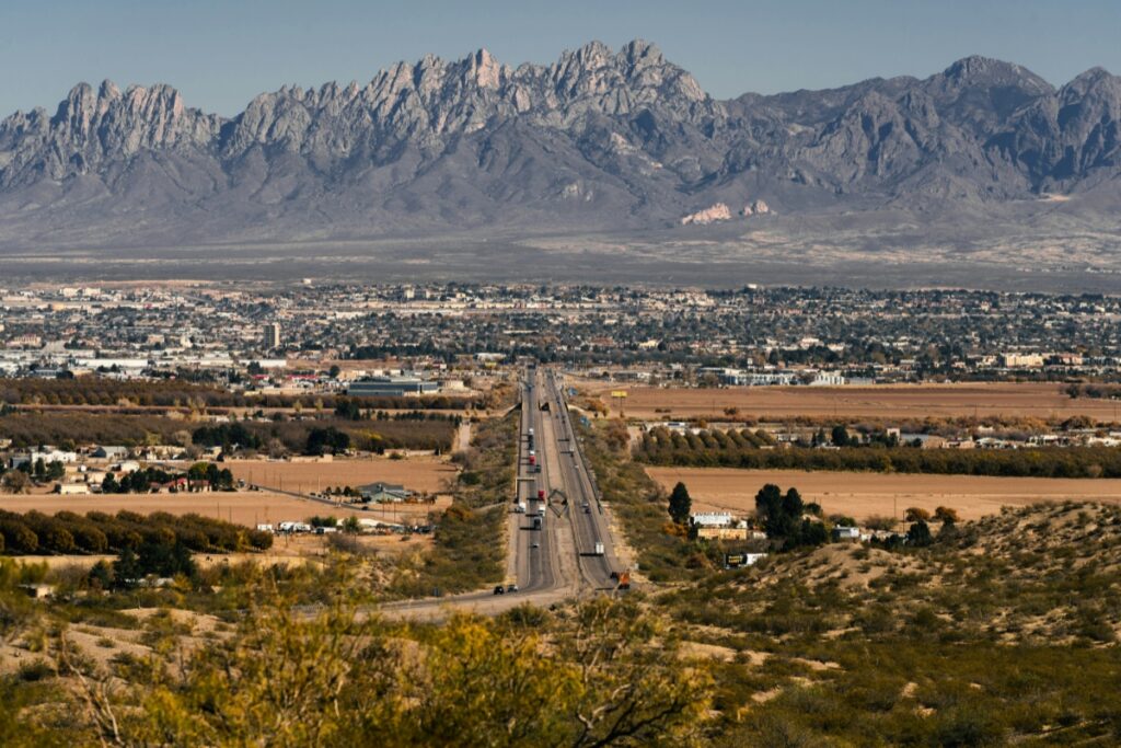 View of Las Cruces, New Mexico with a highway leading into the city and the Organ Mountains in the background
